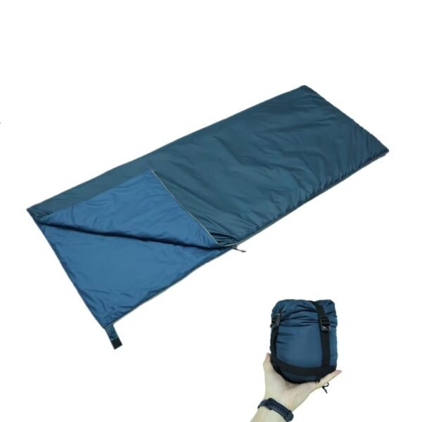Teal envelope sleeping bag with partially folded lining and storage bag